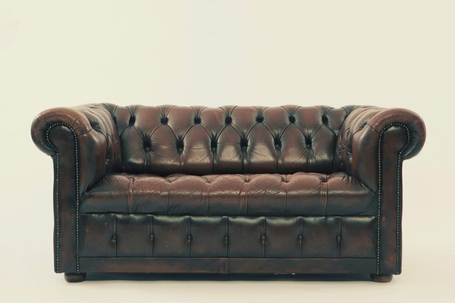 The Chesterton Sofa, a chestnut leather Chesterfield with deep button-tufting.